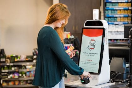 Mapco store woman scanning phone at self checkout
